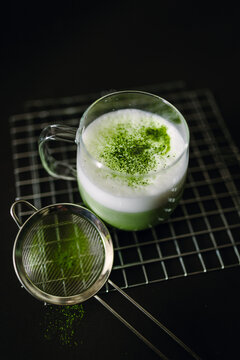Delicious matcha latte with frothy milk and powder garnish