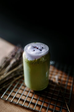 Matcha latte in glass with frothy purple lavender foam
