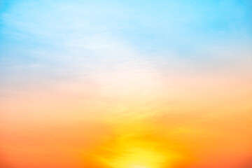 Fototapeta premium Beautiful sunrise sky with vibrant gradient orange and gold colors and soft blue, Clear atmosphere with wispy clouds. Peaceful, perfect for background and copy space, High resolution images