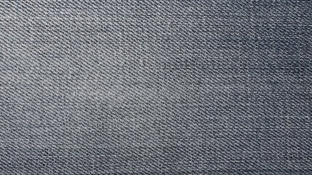 Static top view of worn blue denim fabric with visible texture and faded details. Minimal textile background, distressed jeans material surface for design and fashion concepts.
