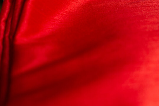 top-view view of bright red satin fabric, forming beautiful waves.