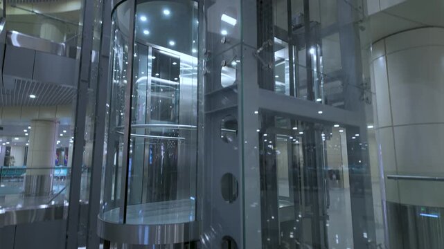 Glass elevator movement in the modern atrium of a commercial building