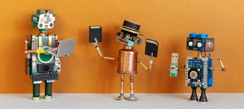Three robot tech users holding laptop, memory cards and usb stick. Modern technology concept, gadget display poster, digital lifestyle banner