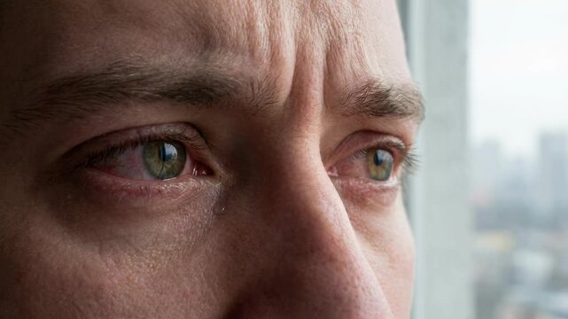 A close-up captures a man's contemplative gaze, his eyes reflecting a mix of curiosity and concern. A powerful portrait with a look of serious thought.