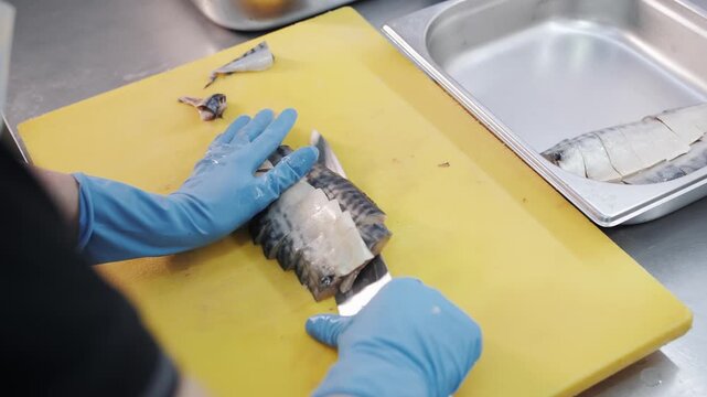 Professional chef performing super fast real-time slicing of raw herring fish fillet