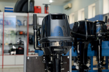 Outboard motor in the showroom: close-up of the hull and tiller.