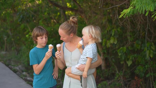 Young mom spending quality time with her two sons in a lush green park, enjoying nature, laughter, and joyful family bonding moments outdoors.