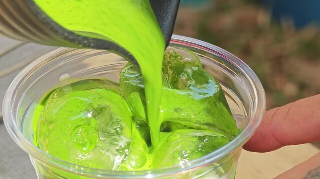 Pouring matcha latte on ice.