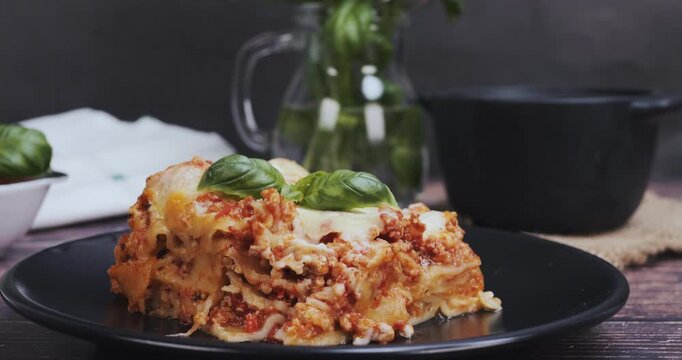 Close-up of a fork taking a bite from a fresh lasagna portion, showcasing Italian cuisine, food texture, and delicious homemade meal concept.