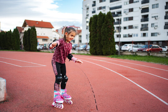 Girl learning rollerblading on outdoor track