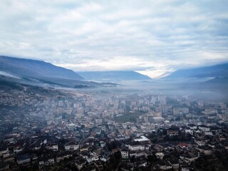 Obraz premium Gjirokastra city aerial panoramic view by misty morning, Albania