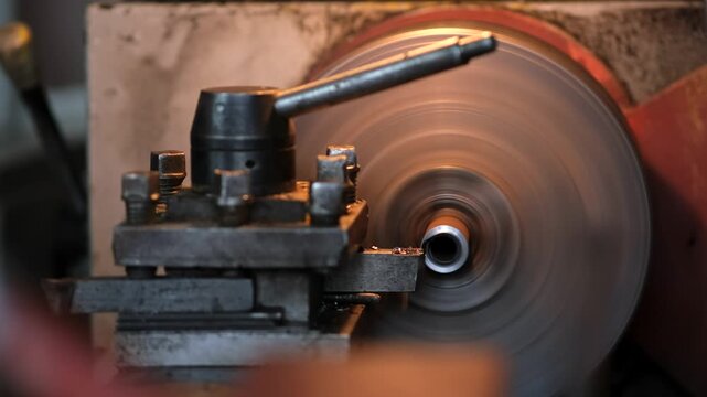 A close-up of a metalworking machine with a spinning metal disc