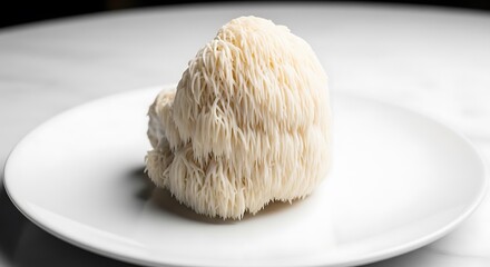 A single lion mane mushroom sits on a white plate