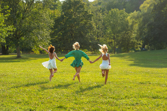 Group of three women friends enjoying  a sunny day of summer in a public park