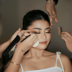 Obraz premium Professional makeup artist applying cosmetics to woman's face