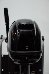 Outboard motor in the showroom: close-up of the hull and tiller.