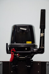 Fototapeta premium Outboard motor in the showroom: close-up of the hull and tiller.