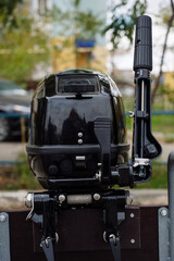 Outboard motor in the showroom: close-up of the hull and tiller.