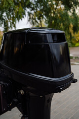 Outboard motor in the showroom: close-up of the hull and tiller.