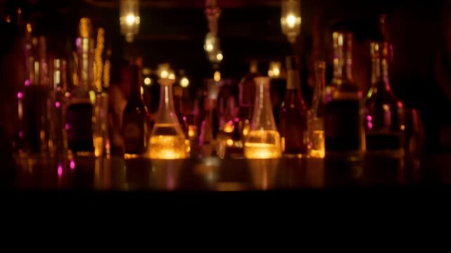 Blurred ambiance of a nightclub or bar with liquor bottles on display illuminating golden light and decorative hanging lamps providing intimate atmosphere
