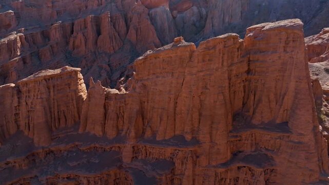 Dramatic sandstone cliffs in desert canyon, Kyrgyzstan - drone view with truck to the right camera movement.