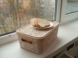 A plate of fresh toast stands near the window. © olvius