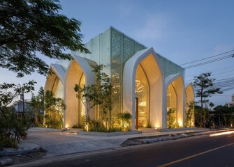 Obraz premium A modern building with arched entryways and a glass facade, lit at dusk