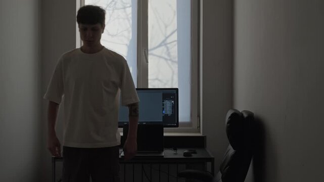 Man stretching in home office during work break, casual remote job routine, simple exercises near desk, real life healthy lifestyle