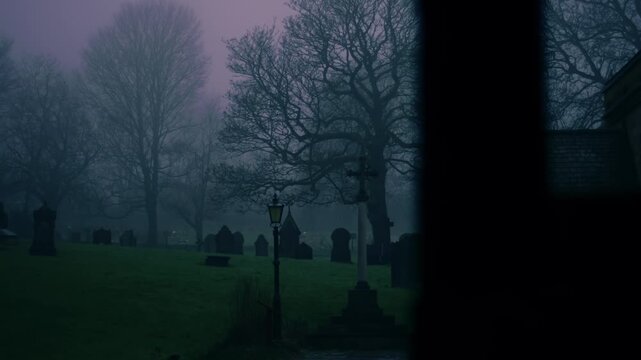 Lonely Graveyard on foggy day though view of church lych gate