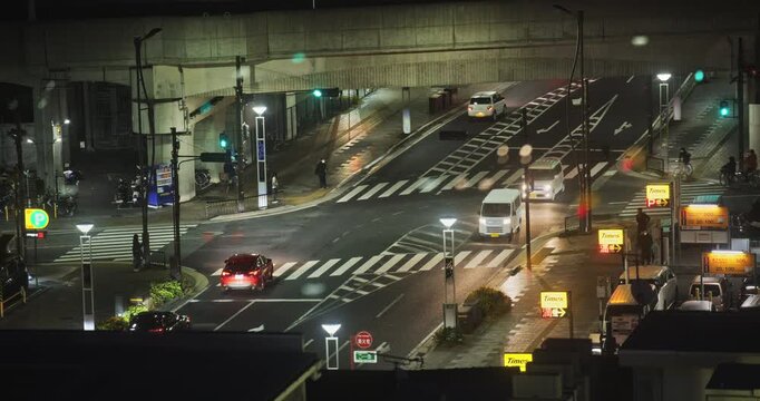 Traffic moving through streets and under underpass - high, locked off shot
