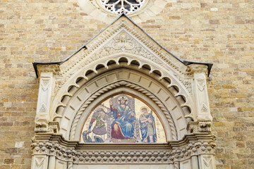 Obraz premium Arezzo, Italy. Close-up of the ornate Gothic portal lunette of the Cathedral of Saints Peter and Donatus, featuring a golden mosaic of Christ enthroned with saints and angels.