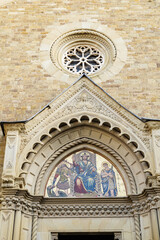Obraz premium Arezzo, Italy. Detail of the main facade of the Cathedral of Saints Peter and Donatus, showing the Gothic portal lunette with golden mosaic, ornate carvings and rose window above.