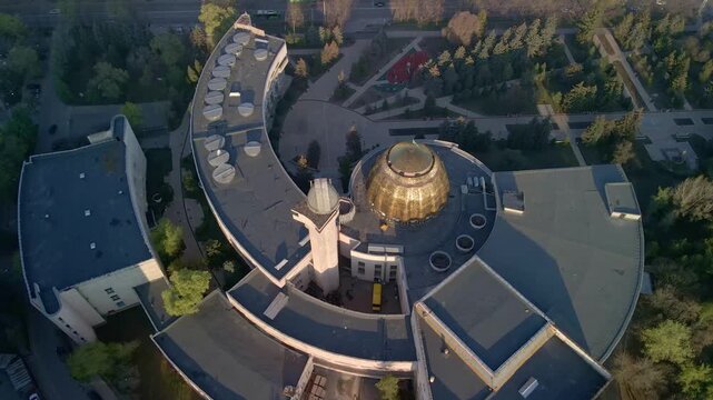 Cinematic aerial drone flight over Almaty city skyline. Panoramic view of modern skyscrapers and historical buildings with snow-capped Tian Shan mountains in Kazakhstan.