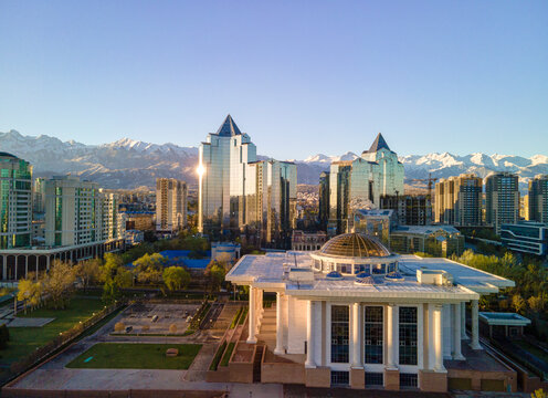 Aerial view of Almaty city skyline with mountains in the background. Modern skyscrapers and historic architecture of Almaty under the Trans-Ili Alatau peaks, Kazakhstan