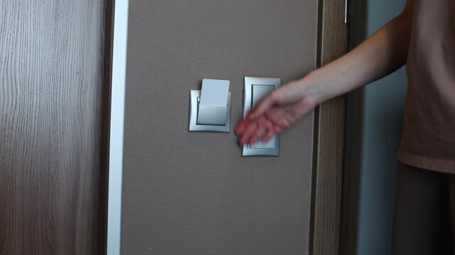 A person inserts a key card into a slot to activate the lights in a hotel room.