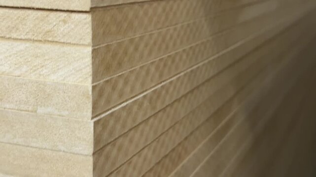 MDF sheets lying in a neat stack in close-up. a product of wood waste recycling. a recycling facility.