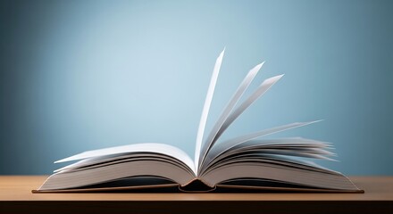 Open book with pages lifted against a soft blue backdrop, on a wooden surface