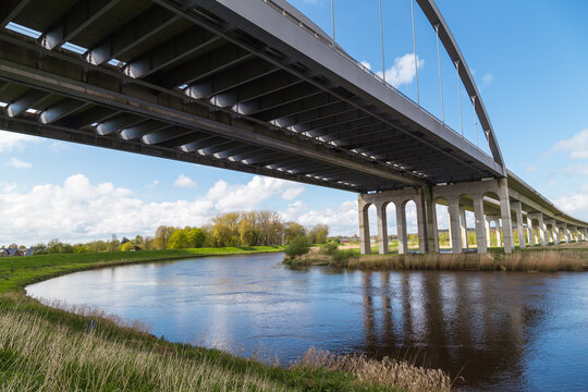 Highway bridge spanning the St&ouml;r River near Itzehoe, Schleswig-Holstein, Germany, under blue sky and spring landscape.