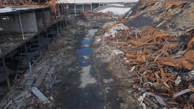 Low drone fly through fire damaged warehouse demolition site