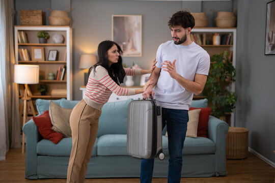 Young couple arguing during relationship crisis, man leaving
