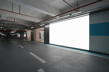 Obraz premium Underground parking garage with blank advertising wall and modern industrial lighting