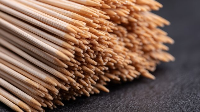 A close-up of a bundle of wooden toothpicks, showcasing their sharp tips and natural color, Perfect for culinary presentations, party decor, and kitchen-related projects,