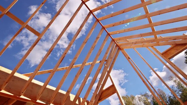 Workers construct new building with wooden beams, trusses framework roofing framing