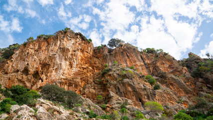 Fototapeta premium Rocky Cliff Face Under Blue Sky With Scattered Clouds