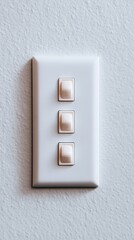 A close-up of a modern light switch panel featuring three buttons, suitable for home interior design projects, electrical installations, or DIY guides