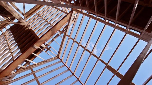 Workers assemble wooden beams for building framework under construction roofing joist