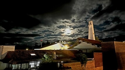 Iglesia colonial bajo la luna llena y nubes nocturnas en Colombia © Dron
