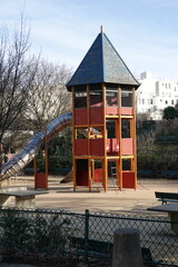 Grand toboggan dans un parc avec une maison en bois &agrave; &eacute;tages