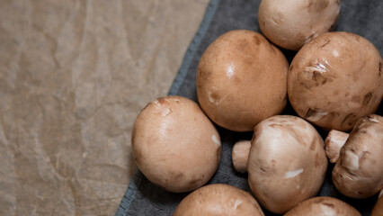 Brown champignon mushrooms on dark fabric background