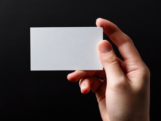 hand holding blank card isolated on a black background